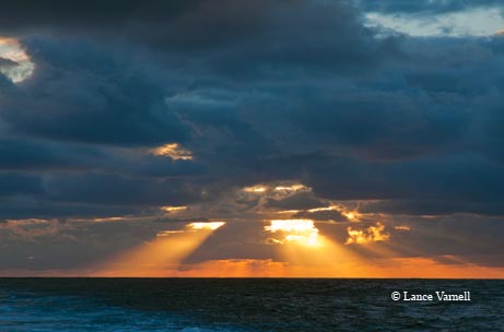 A new day dawns as the sunrise peeks through the clouds over the Gulf of Mexico.