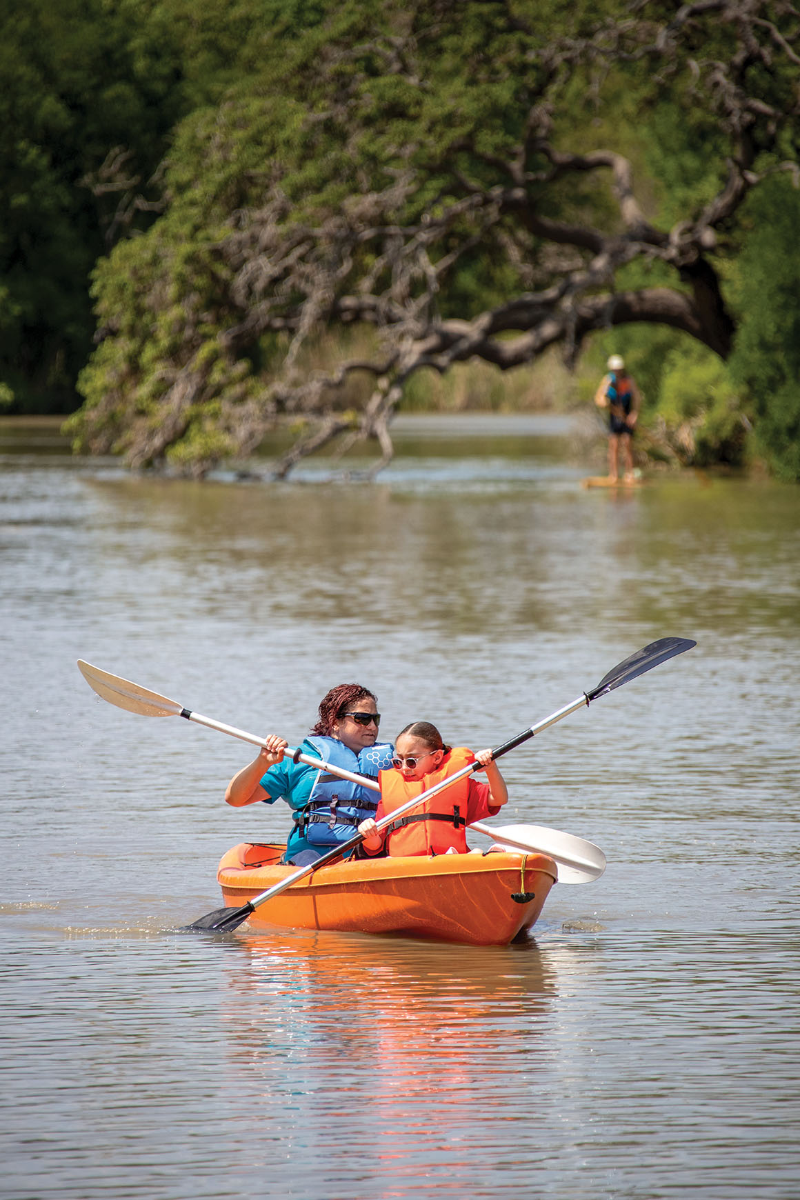 Two children kayak on the water
