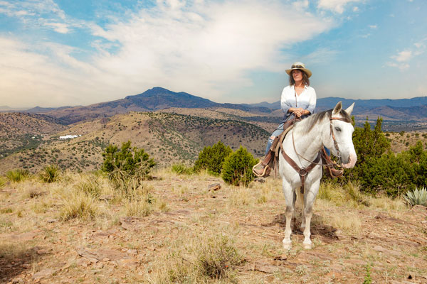 A woman rides her horse along the Limipia Creek Vista trail at Davis Mountains