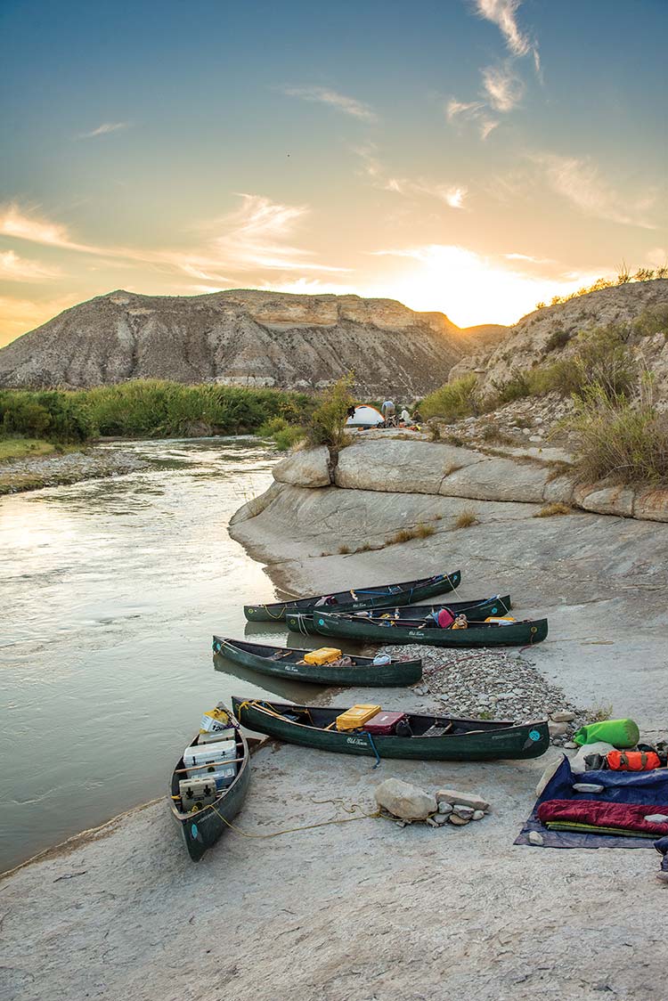 canoe and equipment sit by water