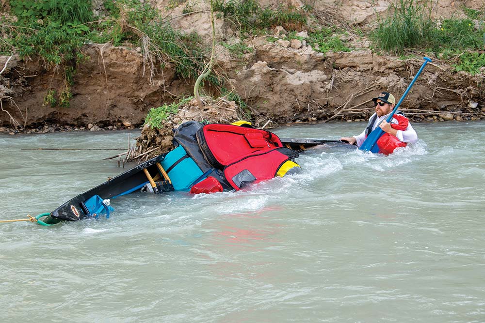 fully loaded canoe taking on rapids