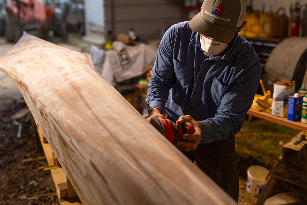 Texas Water Safari paddler Gaston Jones sands the hull of his cedar strip C-1 racing canoe