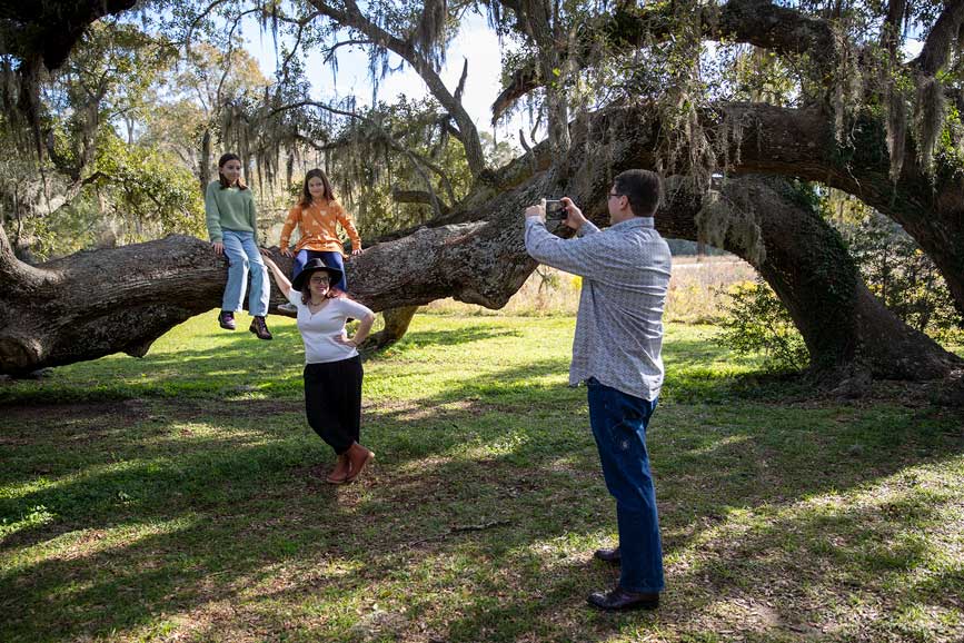 A family poses for a photo against a large tree at Brazos Bend State park