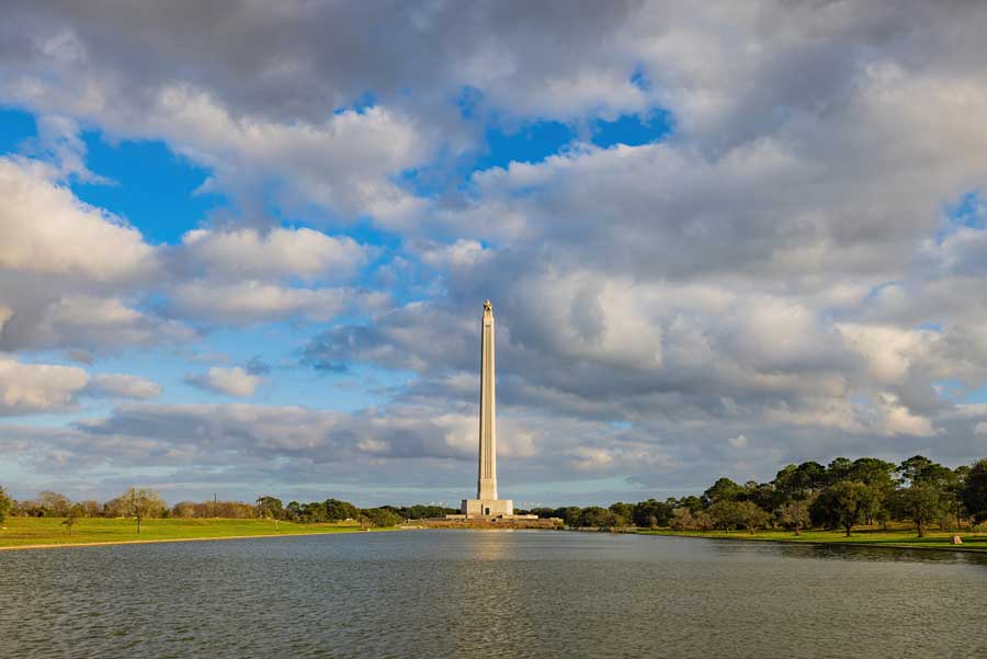 The San Jacinto Monument stands tall above against a cloudy sky