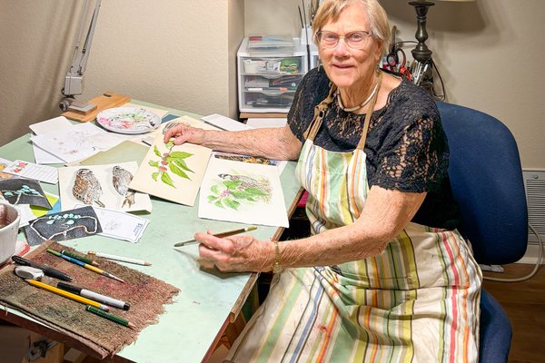 Nancy Pruitt sits at her drawing desk.