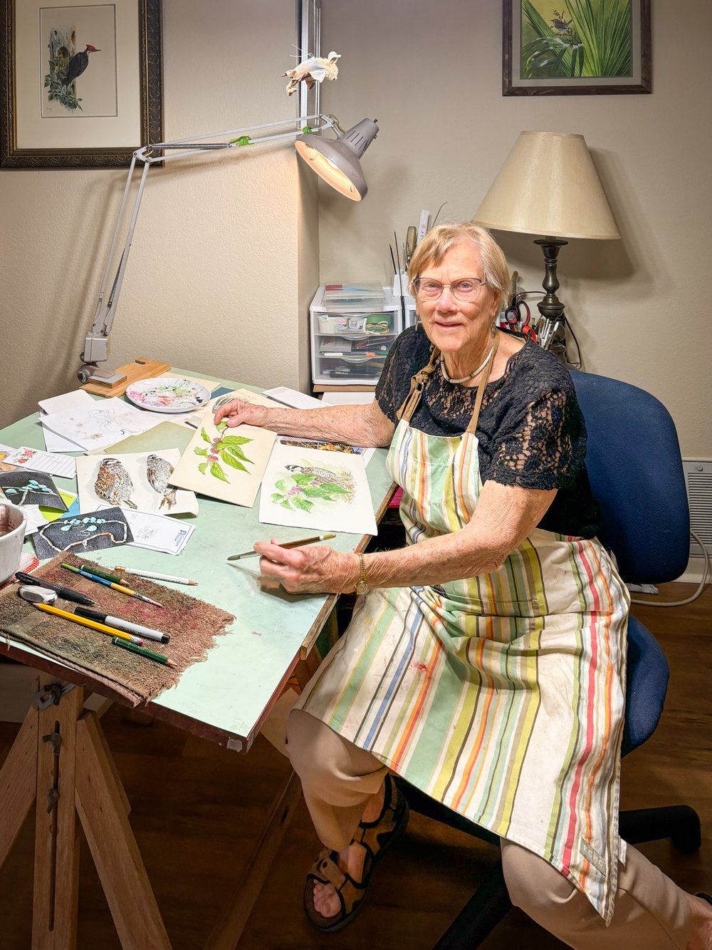 Nancy Pruitt sits at her drawing desk.