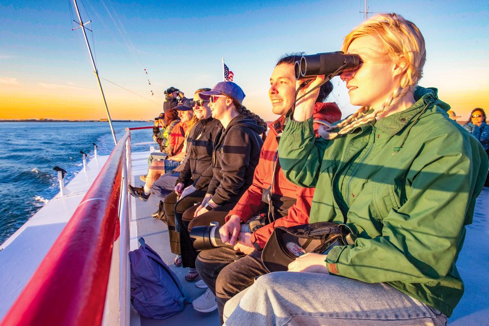 A group of people on a boat look out over the water.