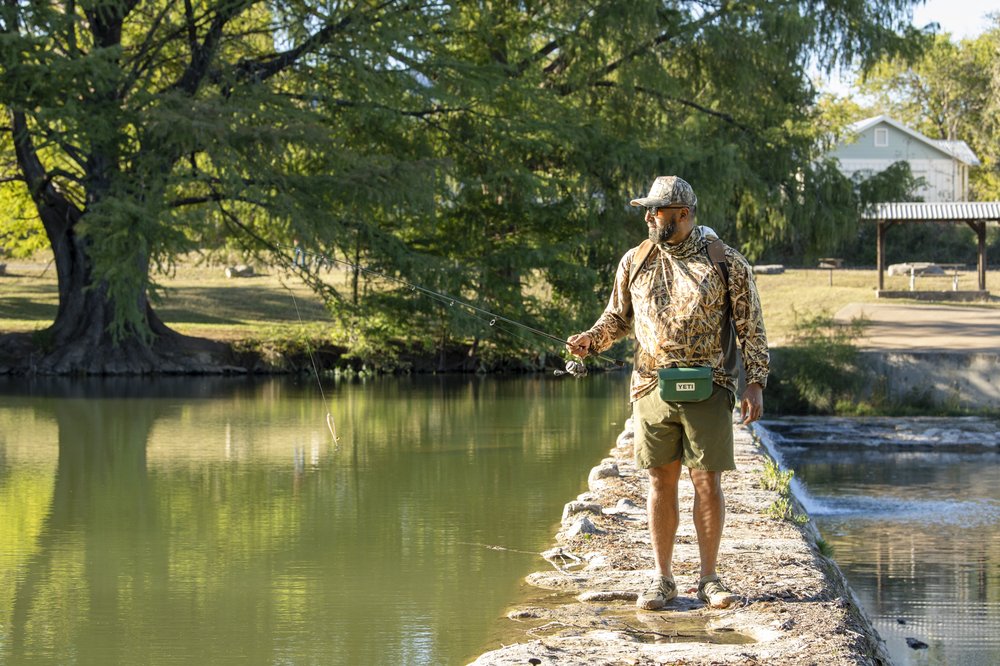 Person fishing from a dam in the river.