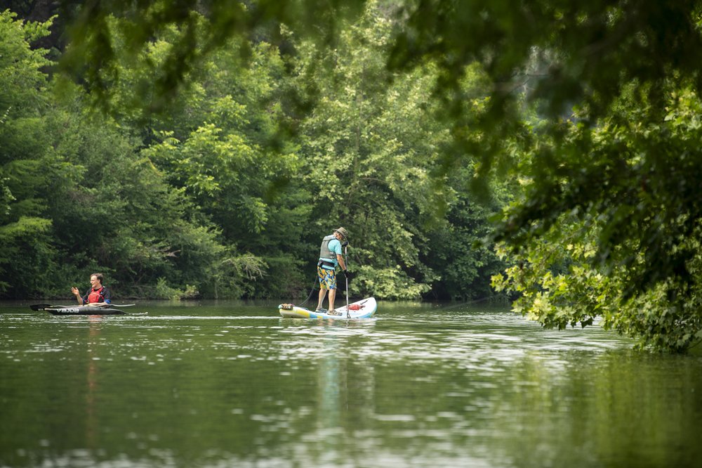 Person in a river on a paddle board.