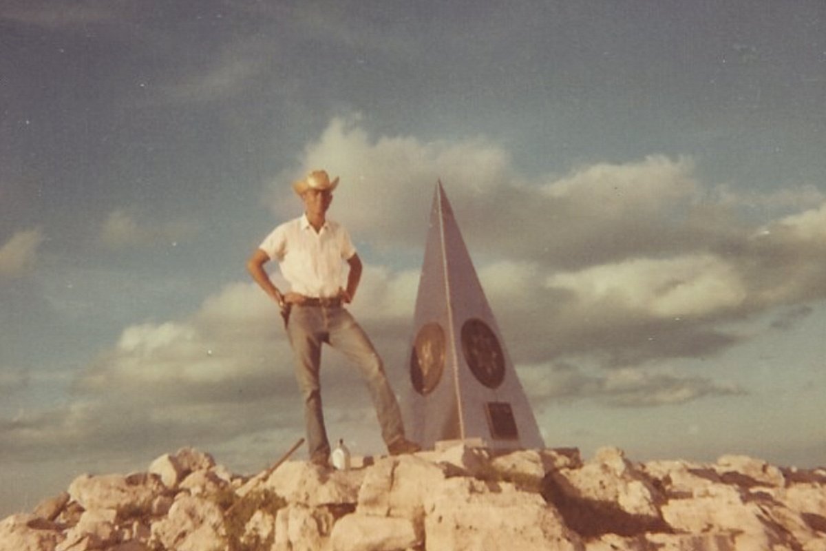 Raymond Urban next to a monument on Guadalupe Peak.