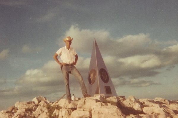 Raymond Urban next to a monument on Guadalupe Peak.
