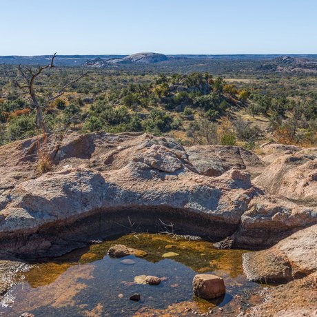A puddle of water surrounded by rocks at an overlook