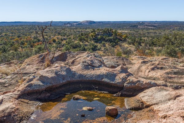 A puddle of water surrounded by rocks at an overlook