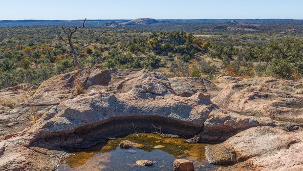 A puddle of water surrounded by rocks at an overlook