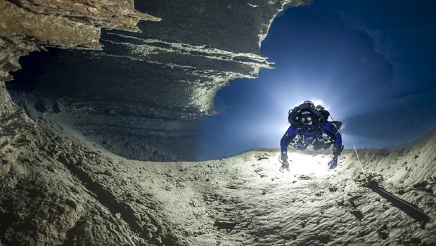Person scuba diving in an underwater cave.