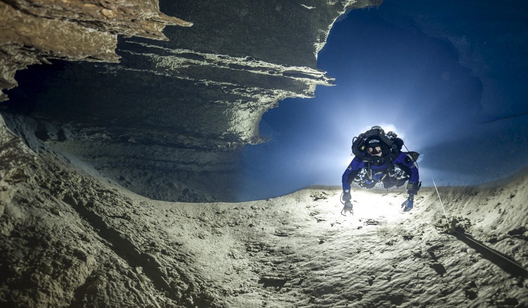 Person scuba diving in an underwater cave.