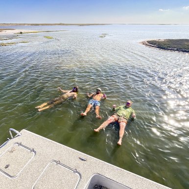 People floating in the water beside a boat.