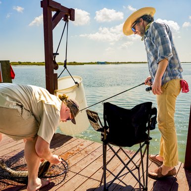 People removing a fish from a hook and net.