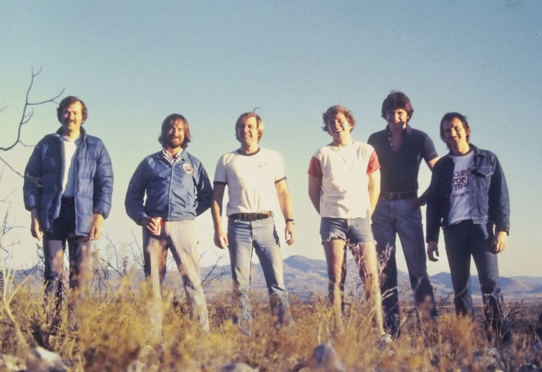 A group of cave explorers standing in a field.