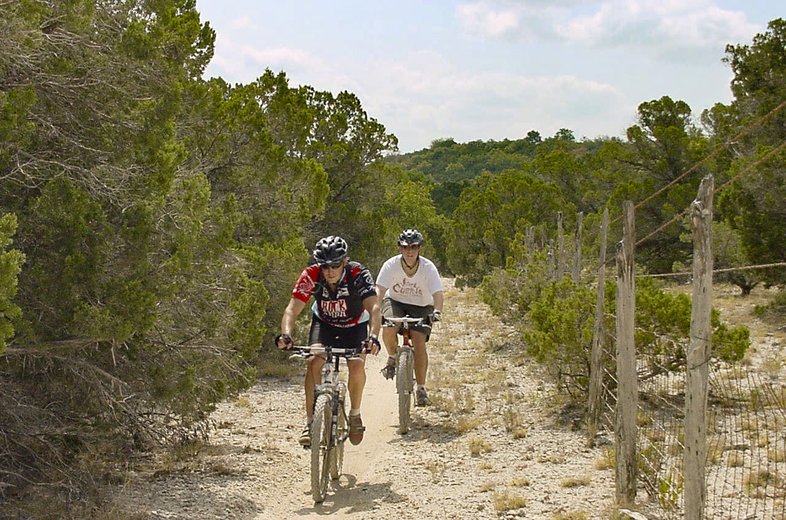 Two mountain bikers on a trail.