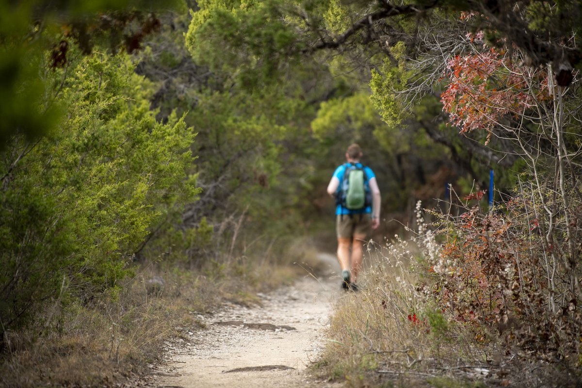 A person walking Fossil Ridge Trail at Cleburne State Park.