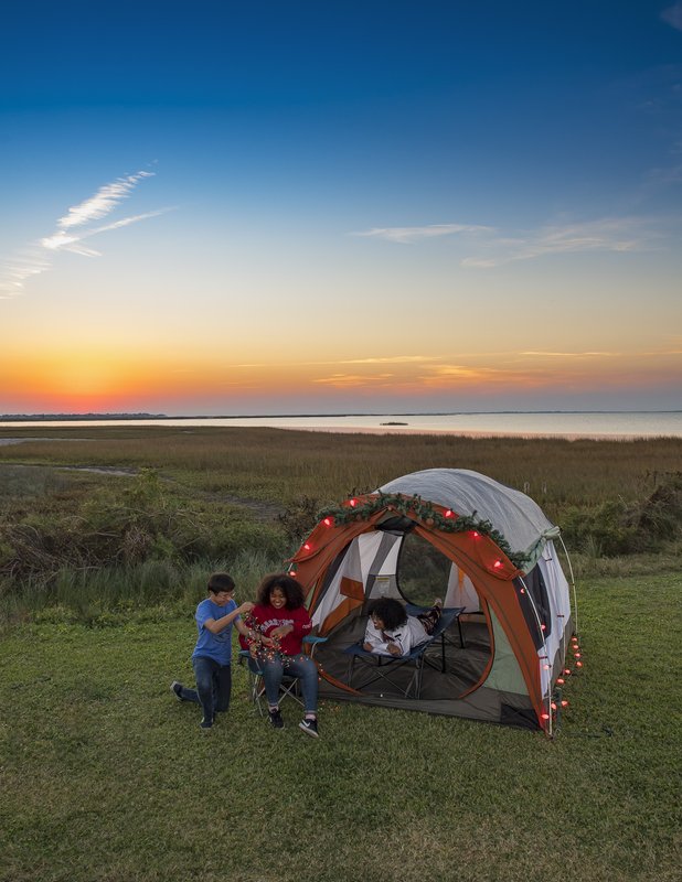 Three people near a tent in Galveston Island State Park