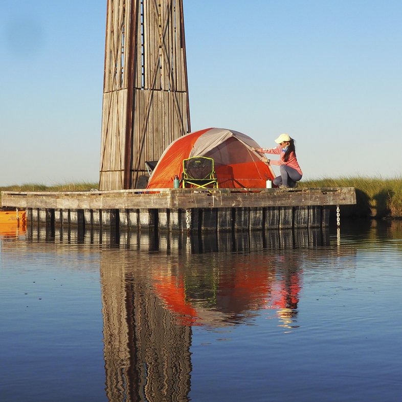 Woman sets up tent on a dock