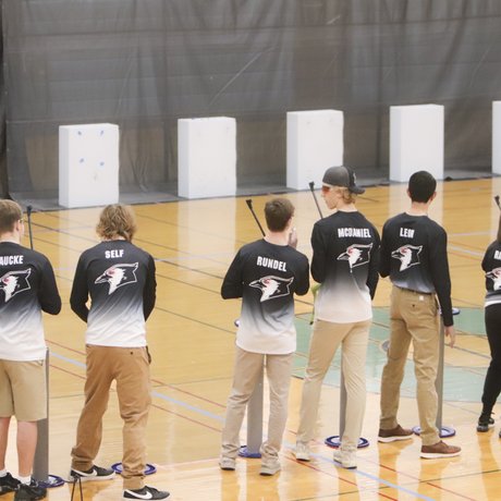 A group of students take aim at targets with air rifles