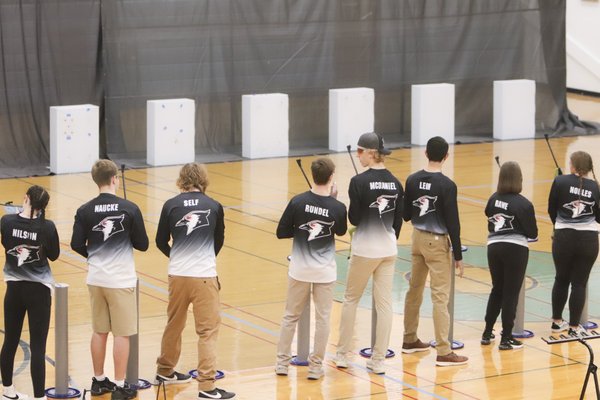 A group of students take aim at targets with air rifles
