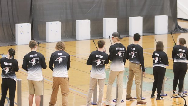 A group of students take aim at targets with air rifles