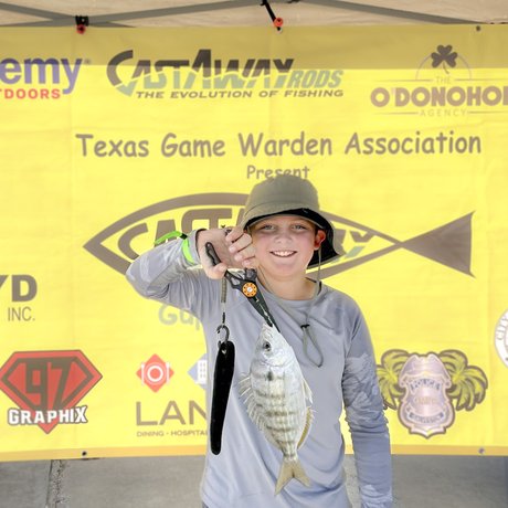 A young person shows off a fish