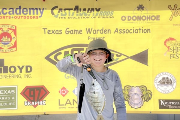 A young person shows off a fish
