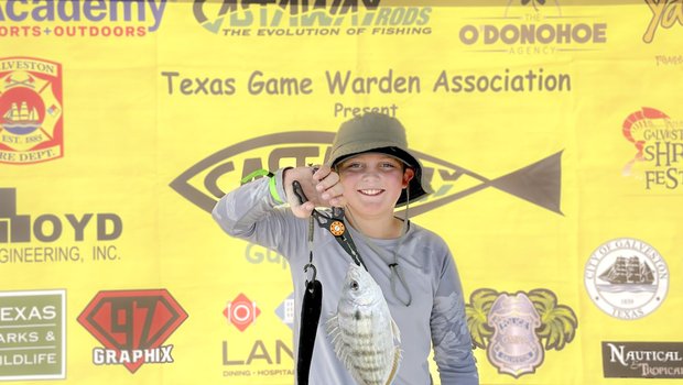 A young person shows off a fish