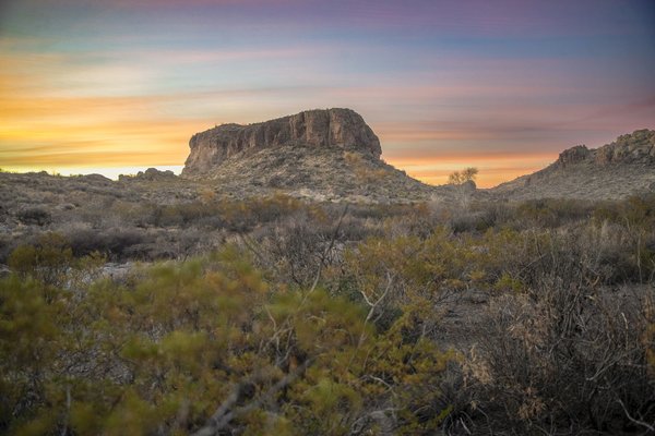 Sun set behind a rock formation.