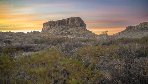Sun set behind a rock formation.