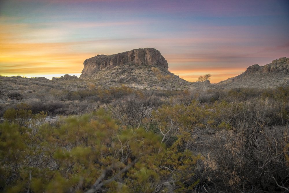 Sun set behind a rock formation.