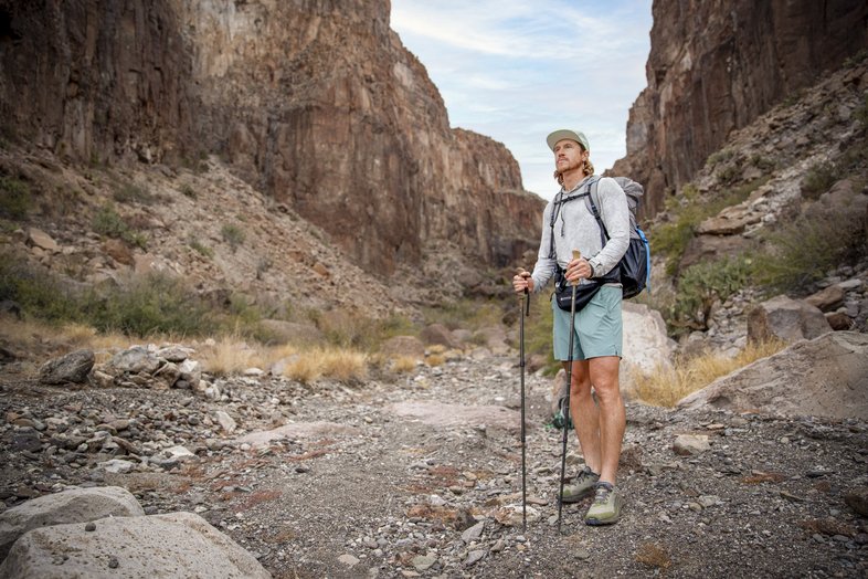 A man with hiking gear on a trail.