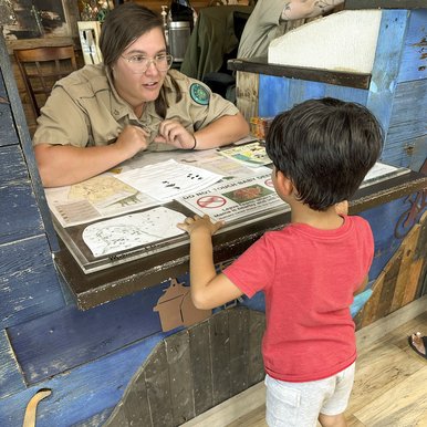 A child talking to a Park Ranger.