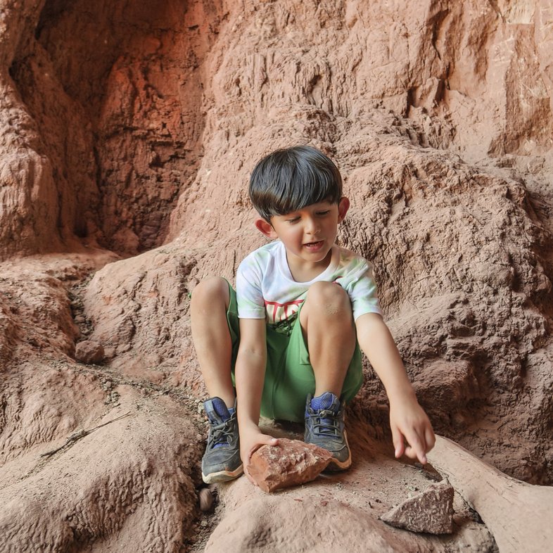 A child sitting in a cave.