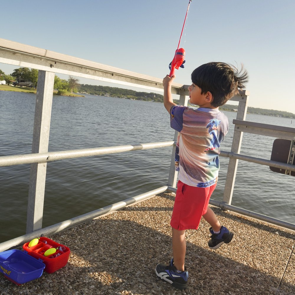 A boy fishing from a pier.
