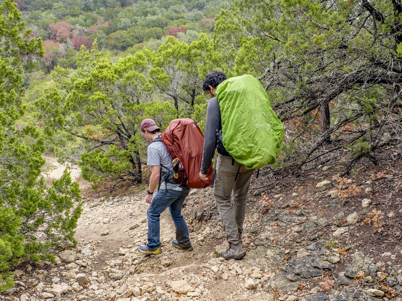Two people backpacking on a trail.