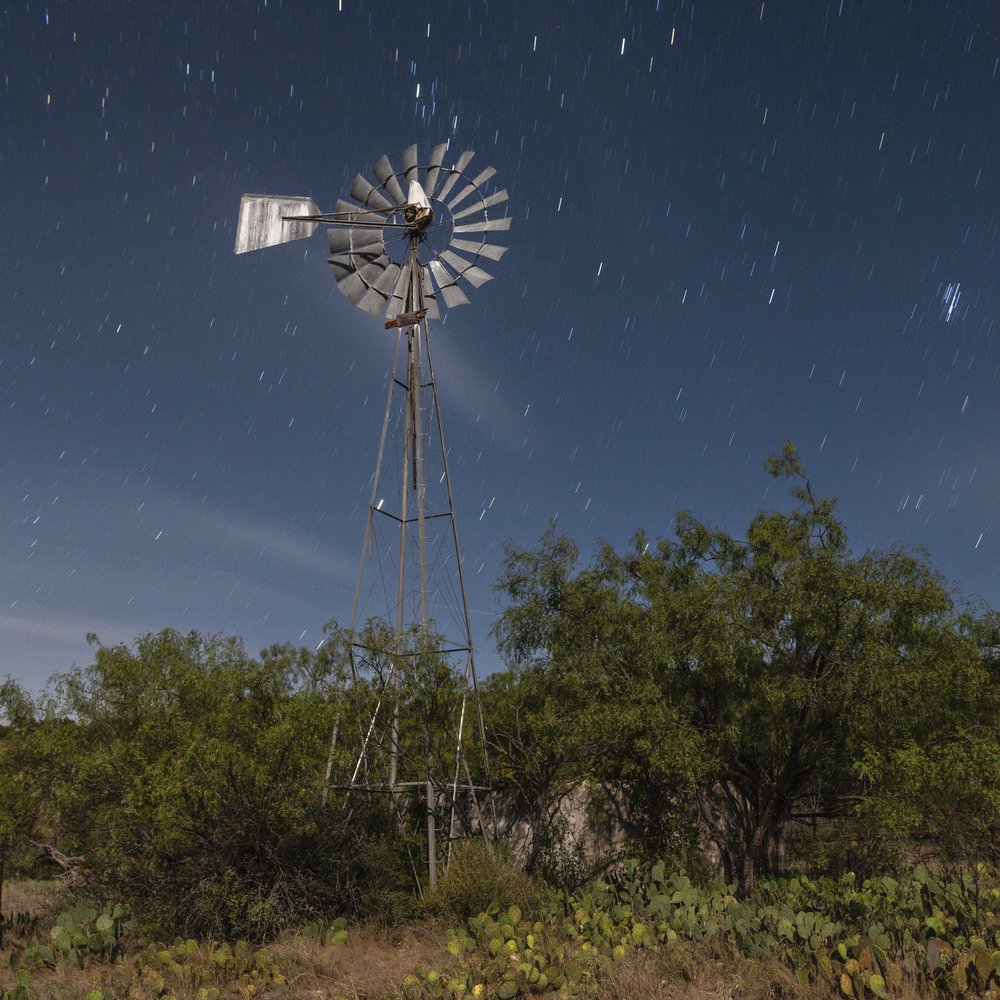 A windmill against a starry night sky.