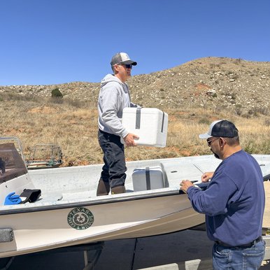 A man holding a white styrofoam box on a boat