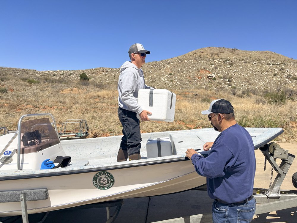 A man holding a white styrofoam box on a boat