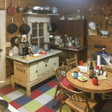A kitchen inside a cabin with pots and pans on the wall