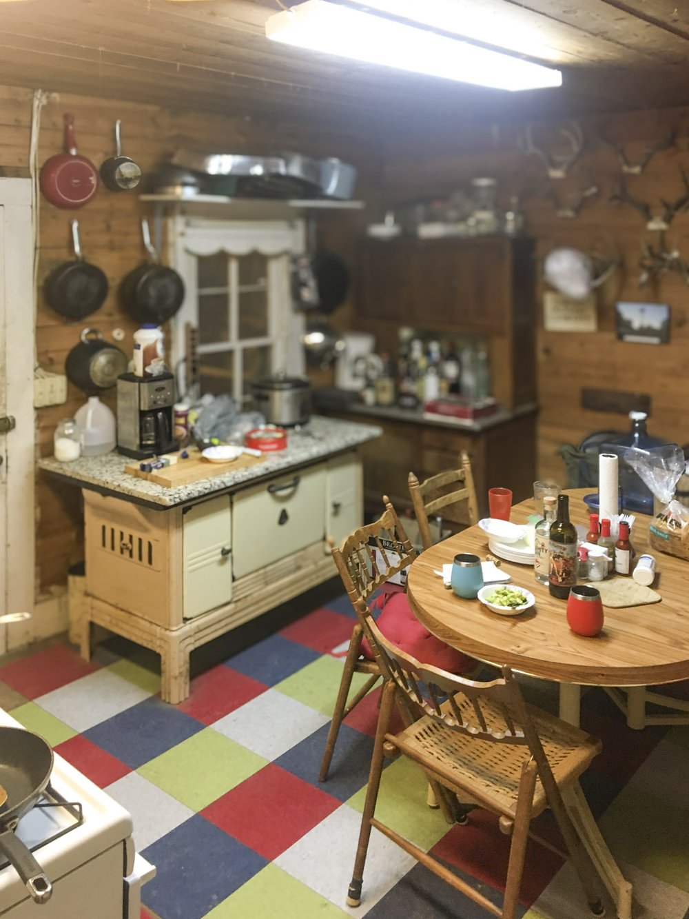 A kitchen inside a cabin with pots and pans on the wall