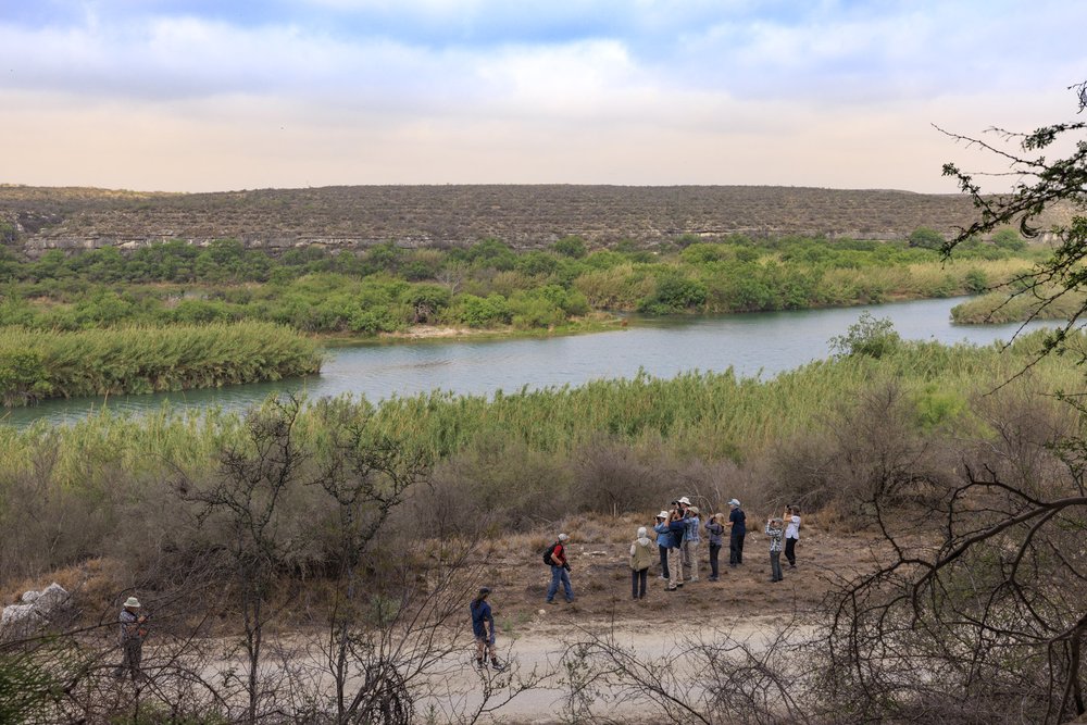 A group of people look through binoculars