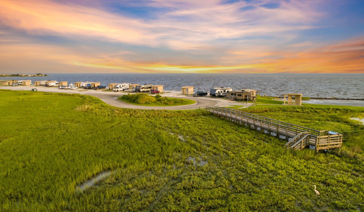 A view of RVs at a camp site by the bay.