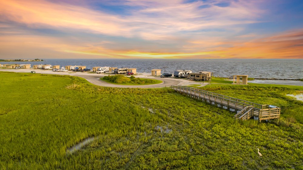 A view of RVs at a camp site by the bay.
