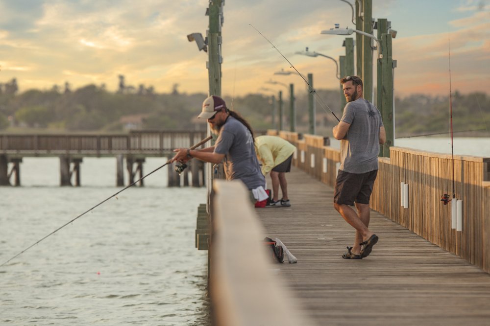 People fishing off a pier.
